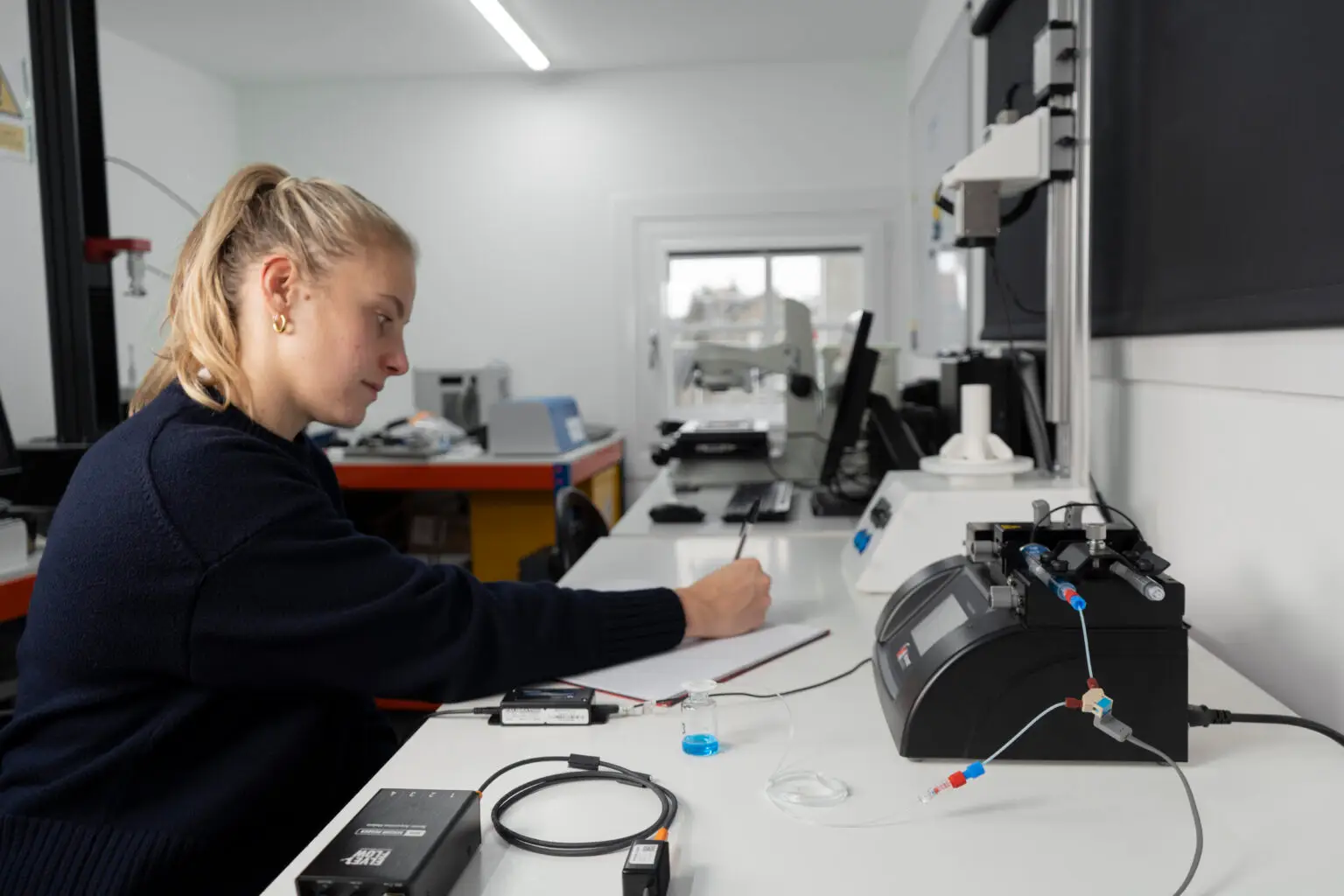 a human factors engineer developing a subcutaneous drug delivery device in a bright test lab